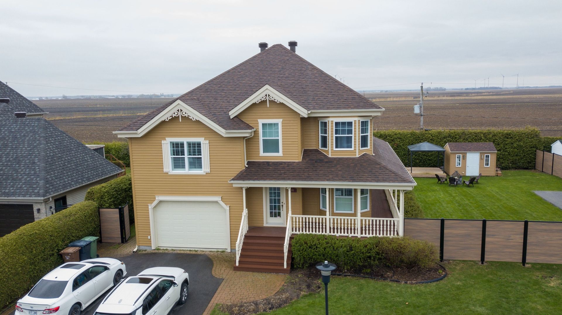 Une vue aérienne d'une maison avec des voitures garées devant.