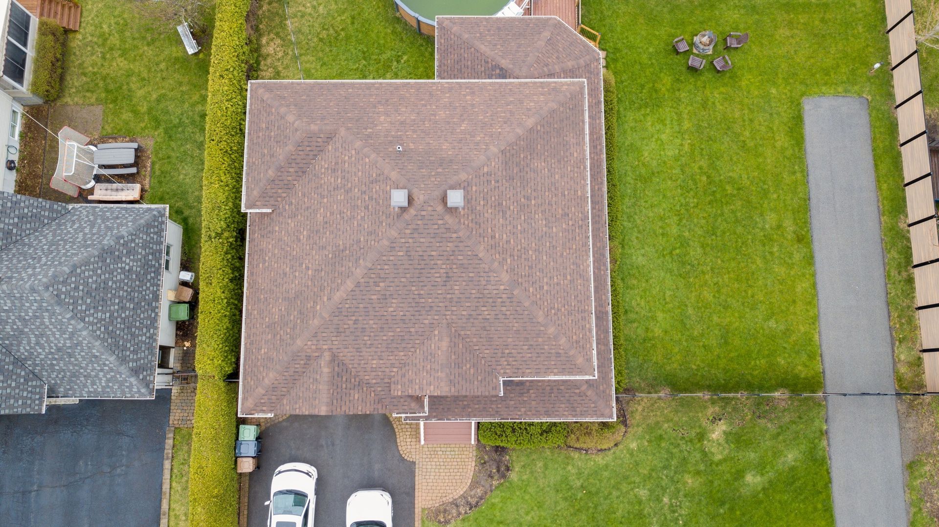 Une vue aérienne d'une maison avec une voiture garée devant.