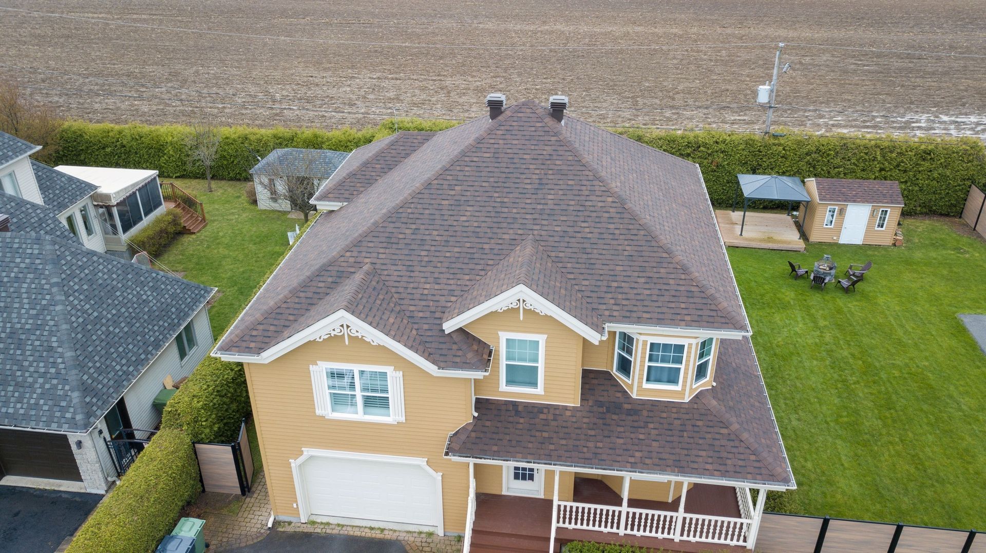 Une vue aérienne d'une grande maison jaune avec un toit marron