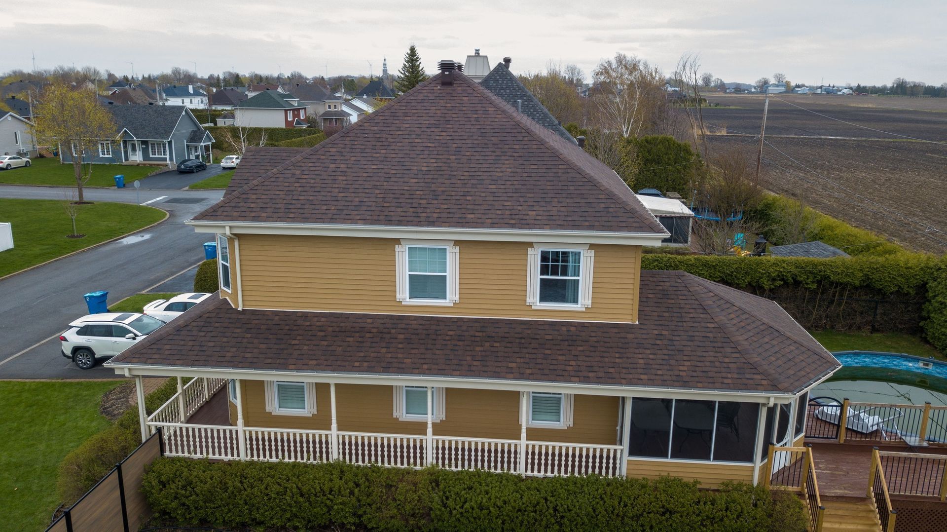 Une vue aérienne d'une grande maison jaune avec un toit marron.