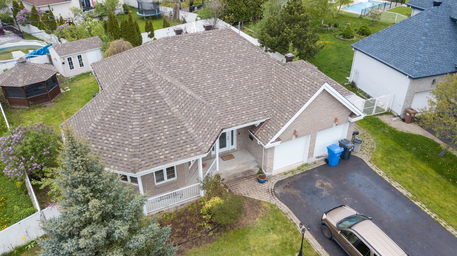 Une vue aérienne d'une maison avec une voiture garée devant.