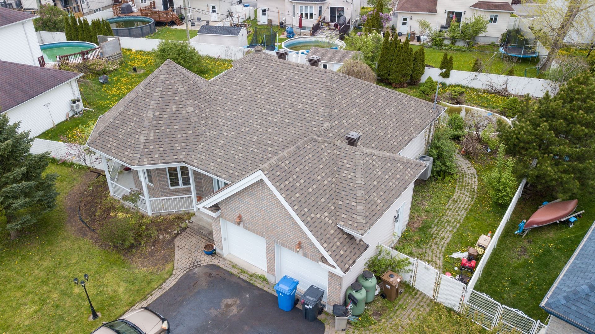 Une vue aérienne d'une maison avec un nouveau toit dans un quartier résidentiel.