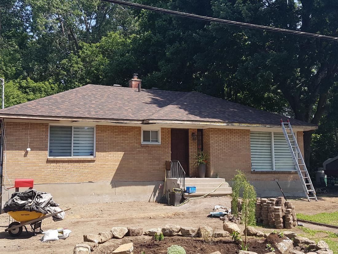 Une maison avec une brouette devant elle est en cours de rénovation.