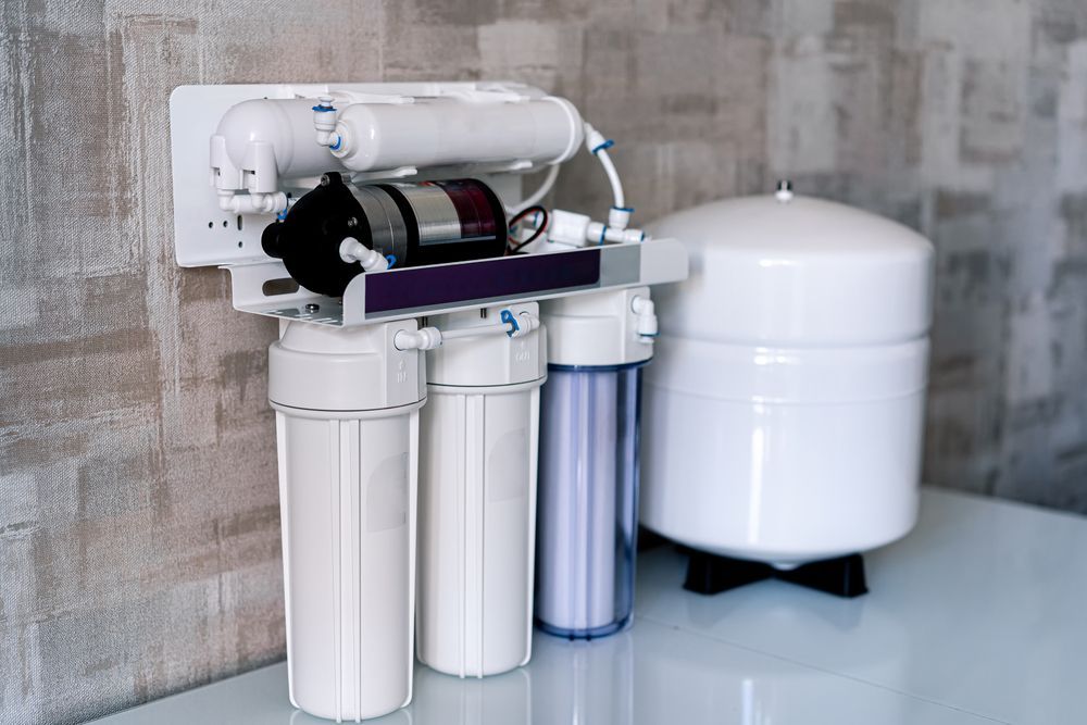 Under-sink reverse osmosis water filtration system with white tanks and blue filter cartridges