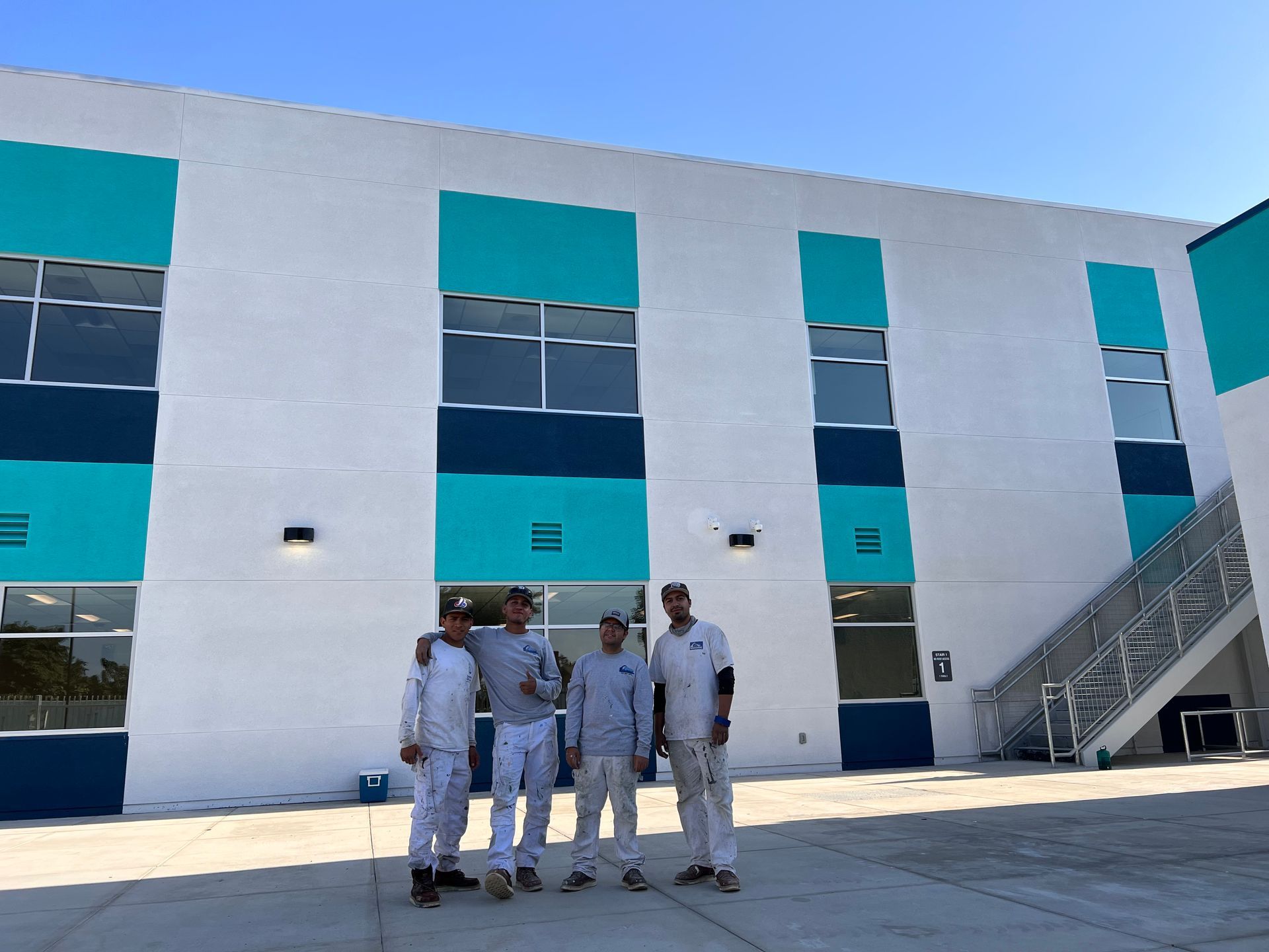 A group of men are posing for a picture in front of a building.