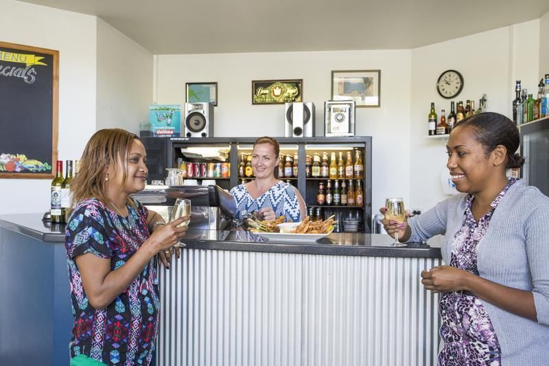 Living Room With Orange Couches — Capricorn Motel & Conference Centre In Parkhurst, QLD