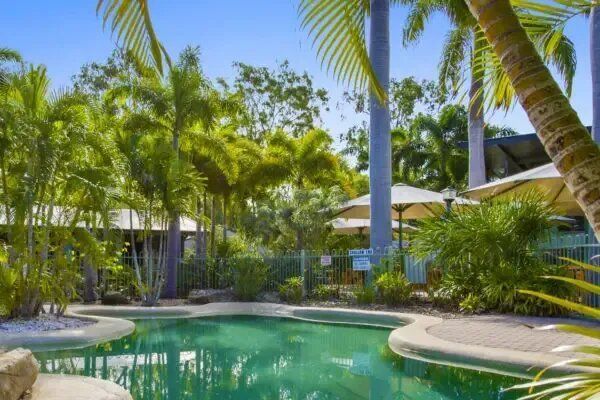 Swimming Pool Surrounded by Palm Trees — Capricorn Motel & Conference Centre In Parkhurst, QLD