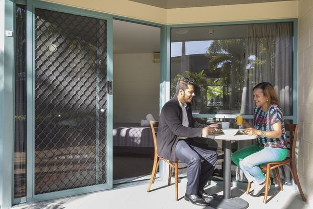 Couple at a Table on a Patio — Capricorn Motel & Conference Centre In Parkhurst, QLD