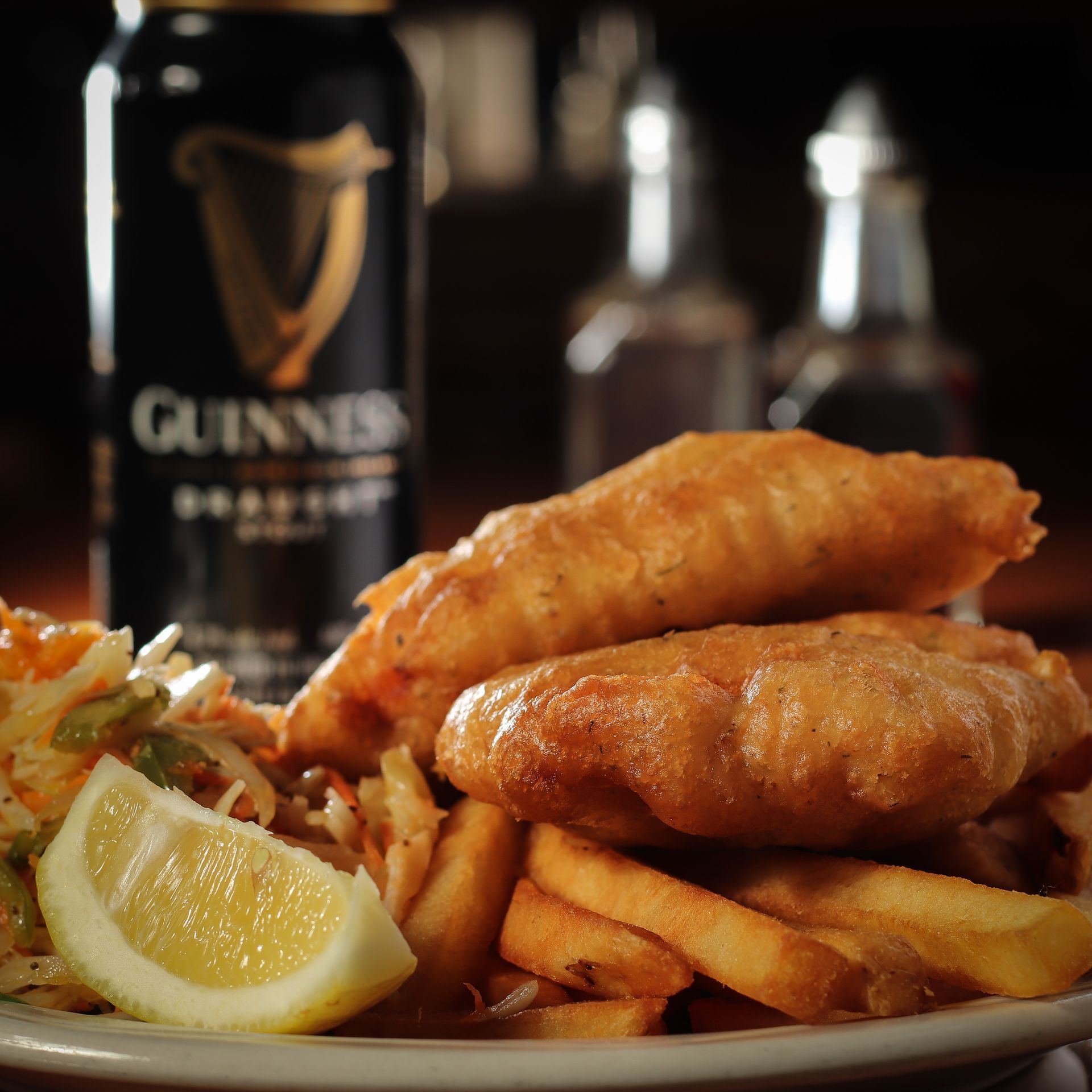 A plate of food with a can of guinness in the background