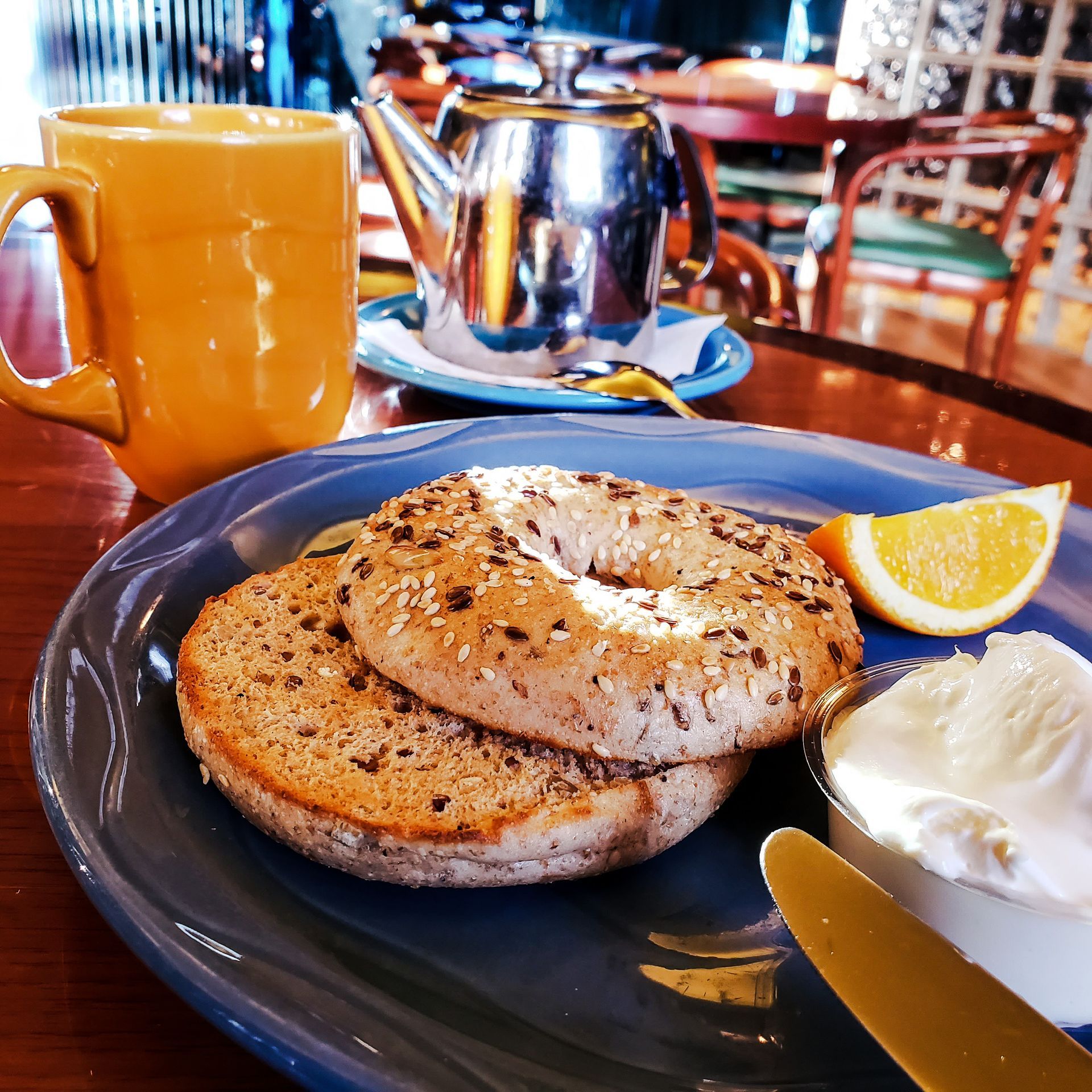 A plate of food with a bagel and sour cream on it