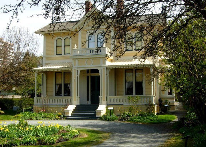 A large yellow house with a porch and stairs