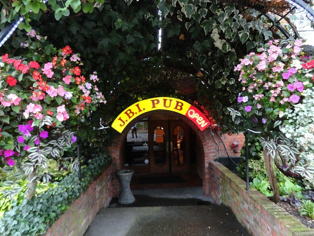 The entrance to the jbl pub is surrounded by flowers