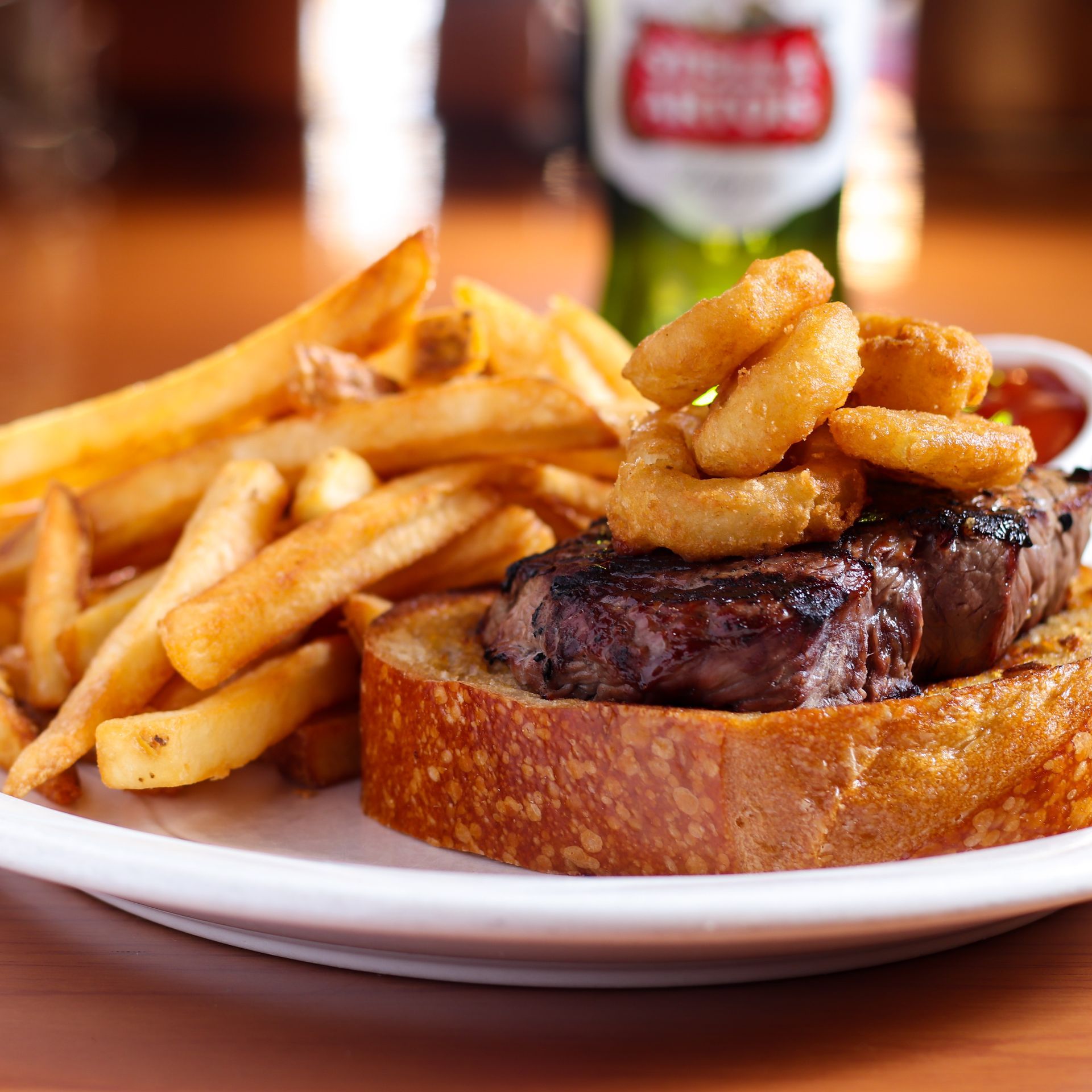 A plate of food with a steak and french fries on a table.