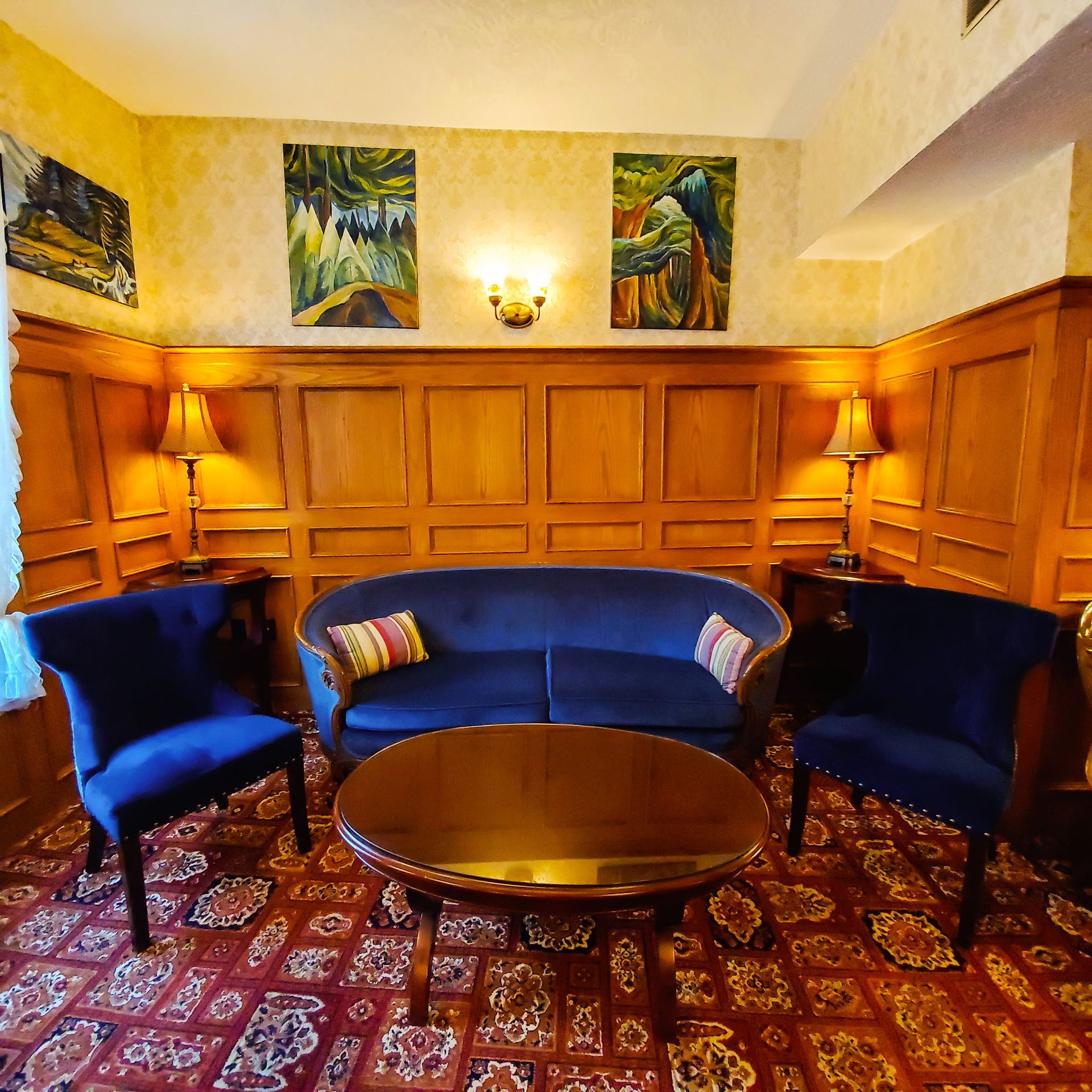 A living room with a blue couch and blue chairs