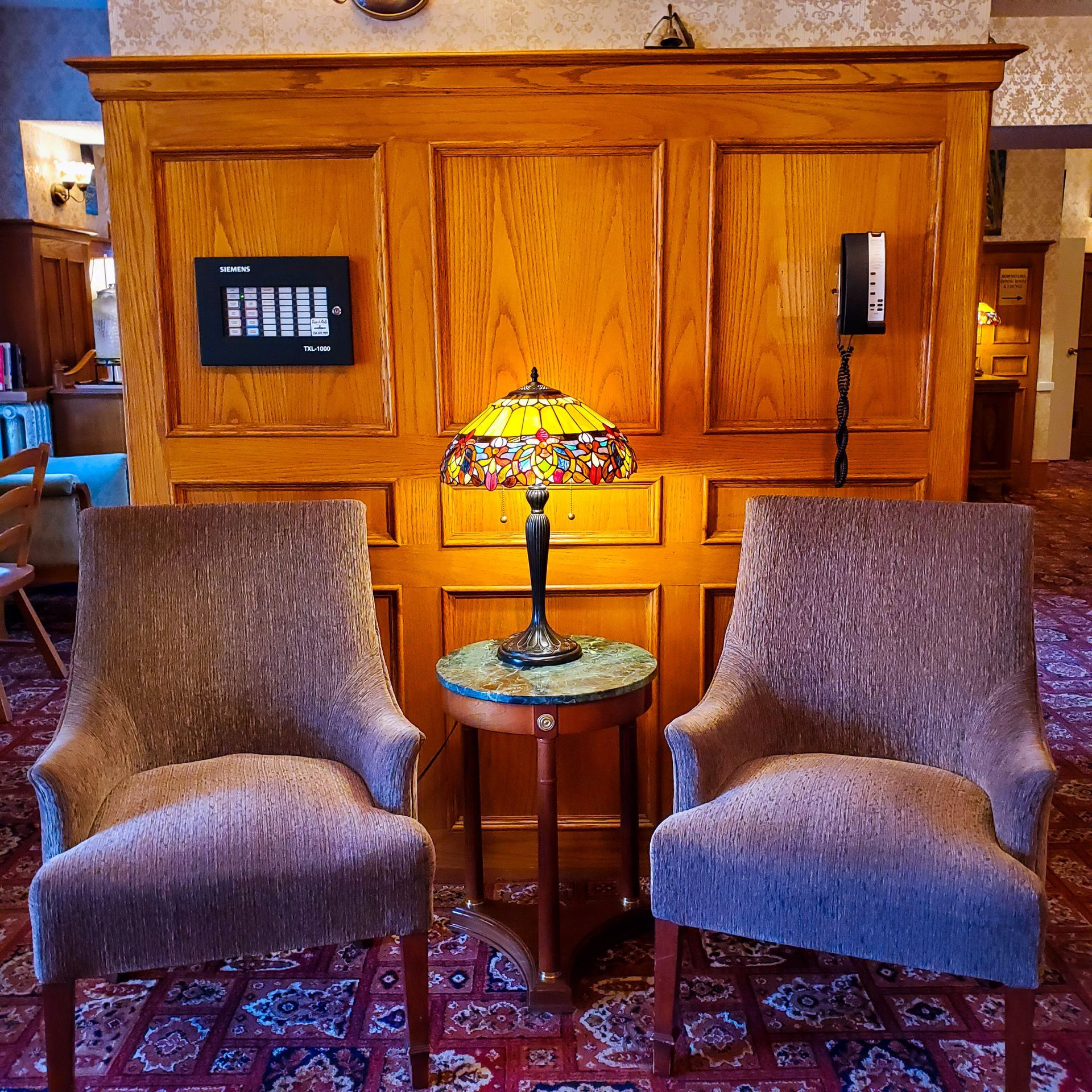 Two chairs and a lamp in a room with wood paneling