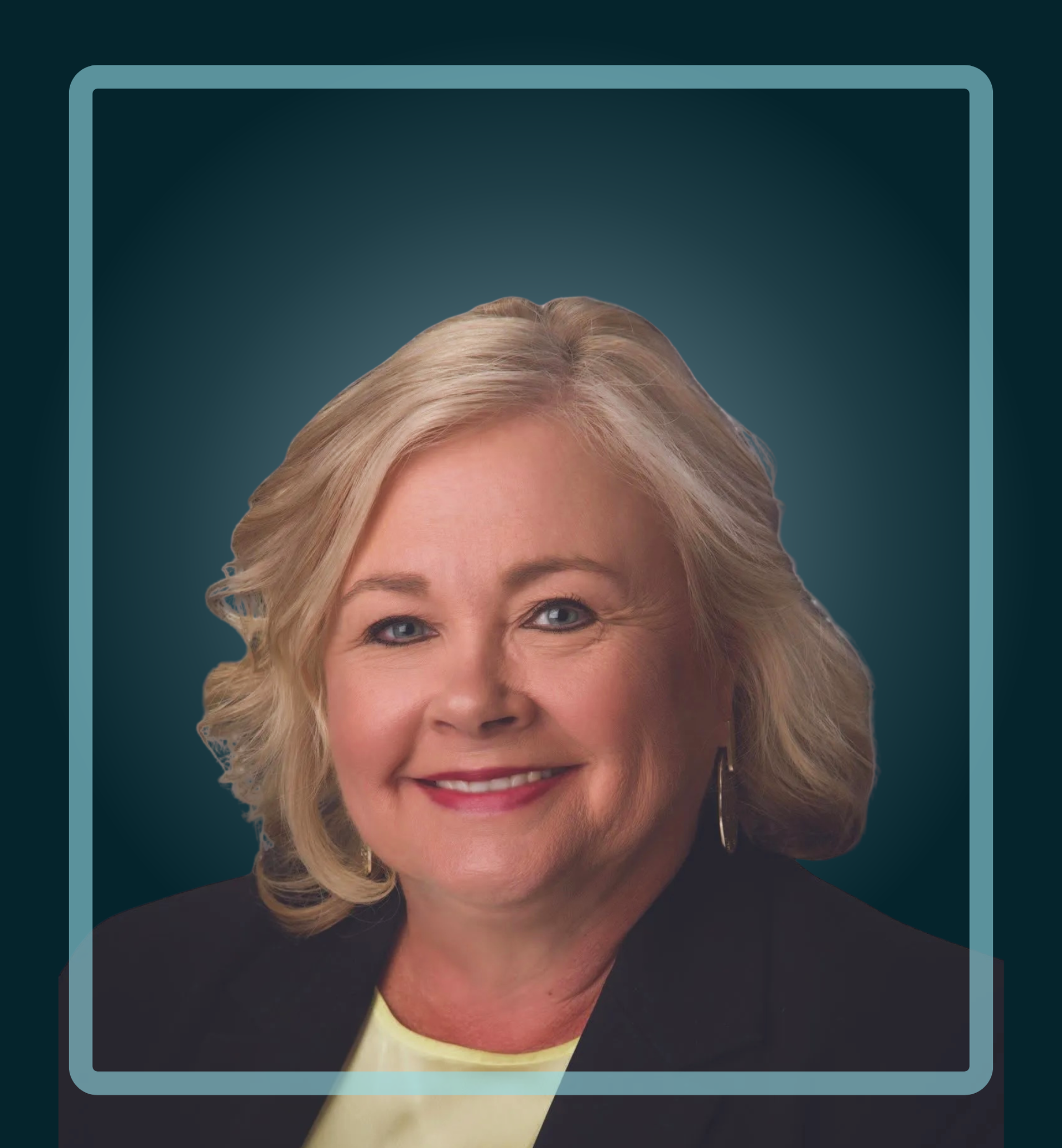 Smiling woman with blonde hair, wearing a black blazer and yellow top, blue background.