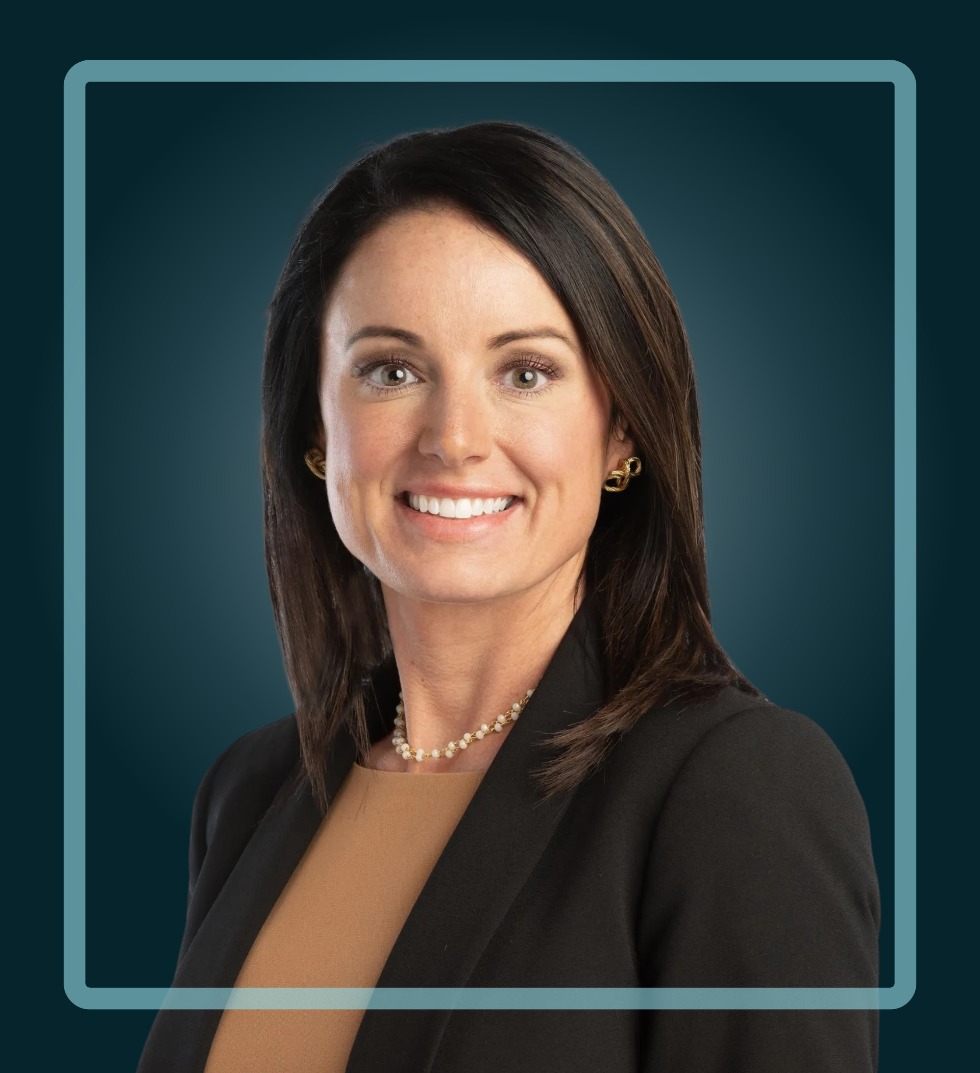 Woman in a business suit smiles, posing for a headshot against a blue background.