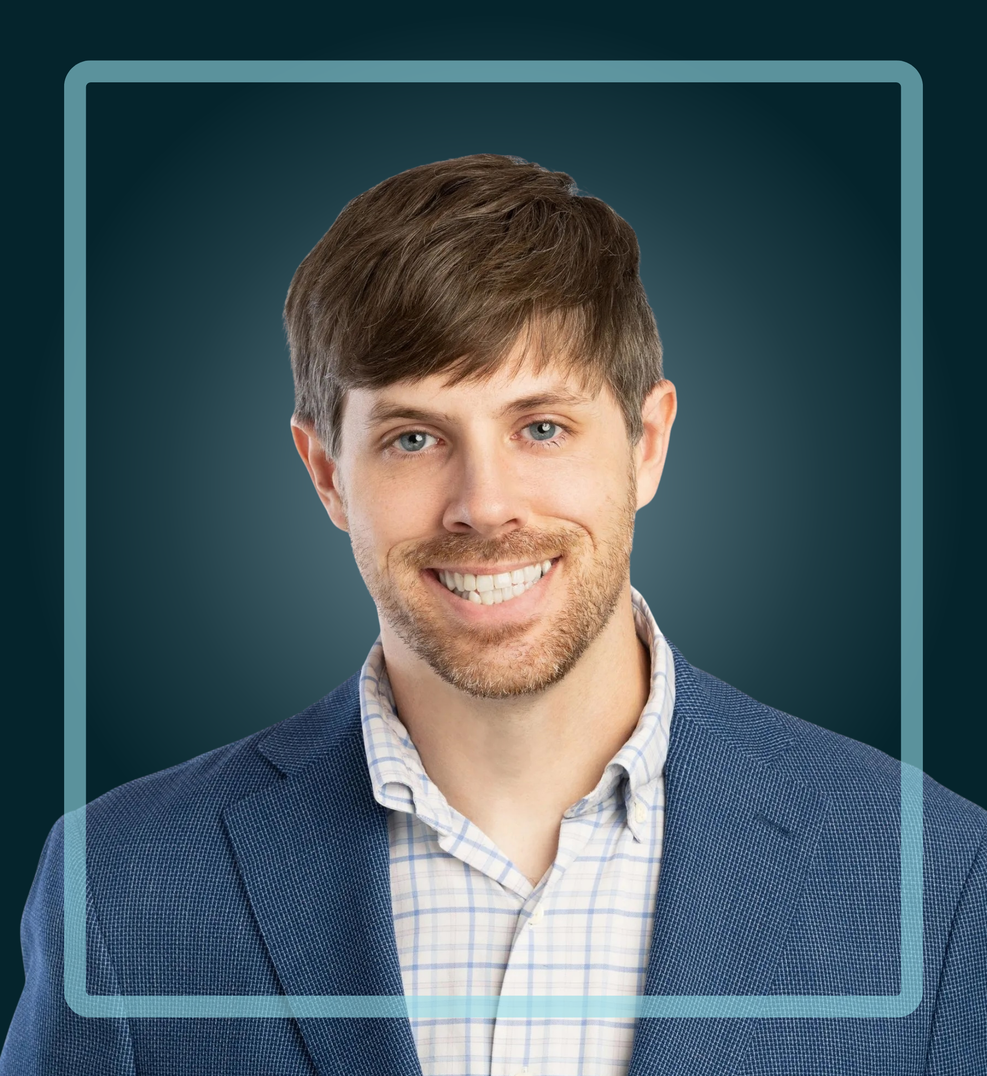 Smiling man in a blue blazer and plaid shirt, framed by a light blue border on a dark teal background.