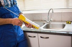 contractor repairing kitchen sink