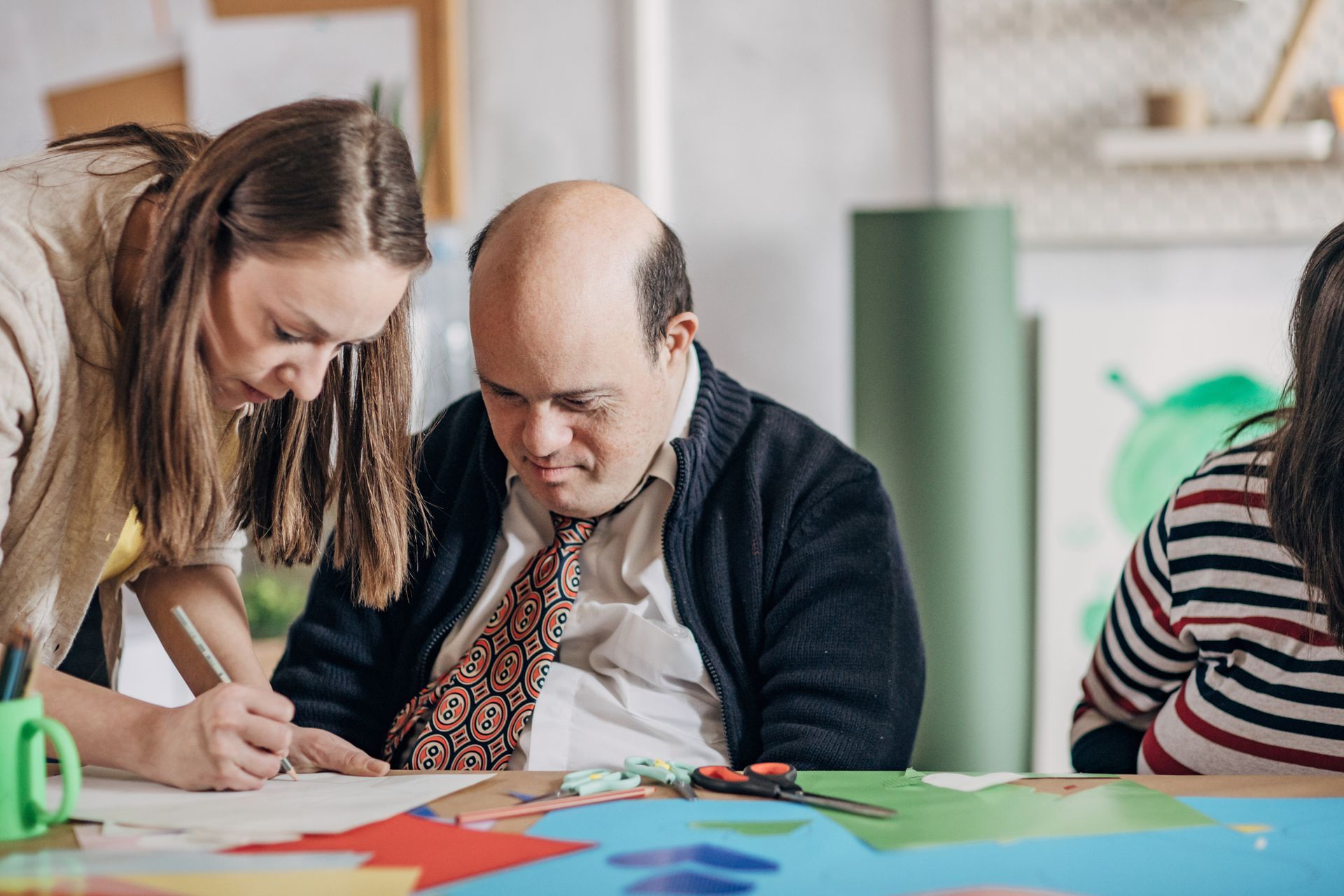 A man and a woman are sitting at a table looking at a piece of paper.