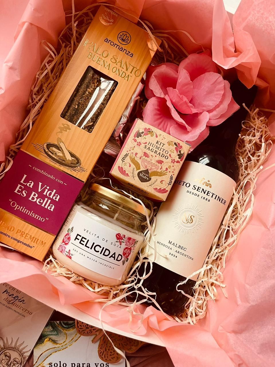 Una caja de regalo llena de una botella de vino, una vela y una caja de pasta.
