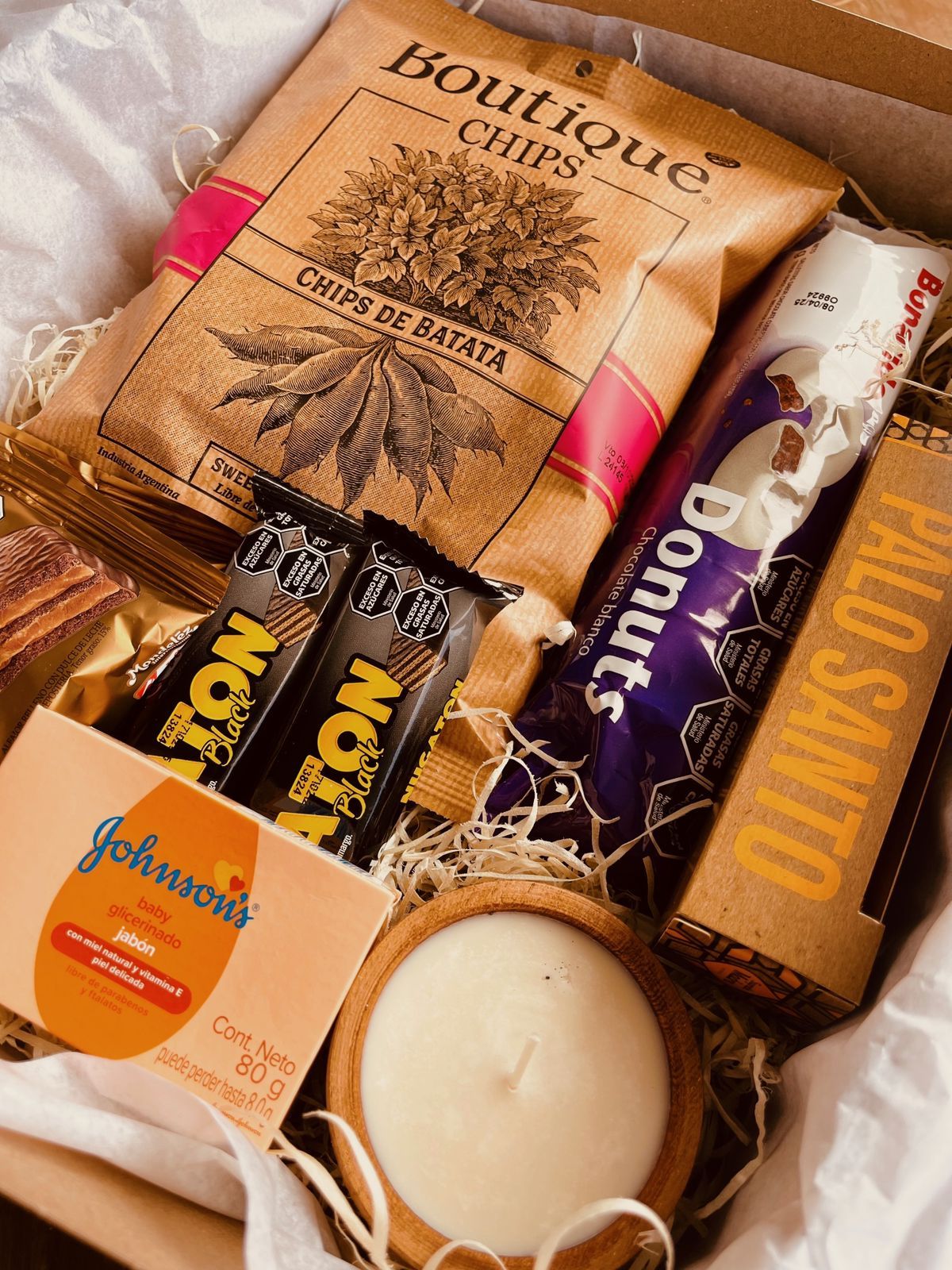 Una caja llena de una variedad de bocadillos y una vela.