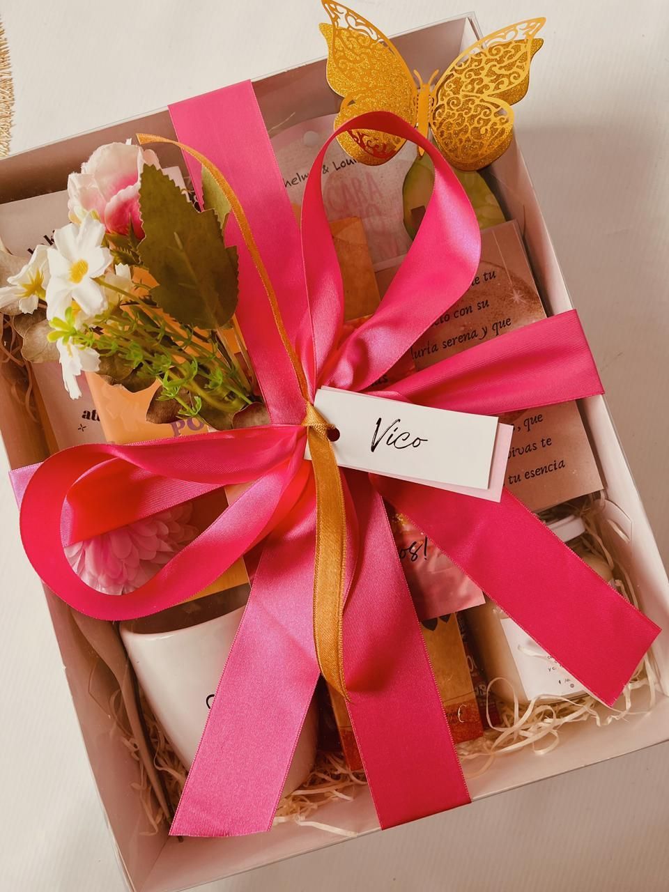 Una caja de regalo con una cinta rosa y una etiqueta que dice vibra