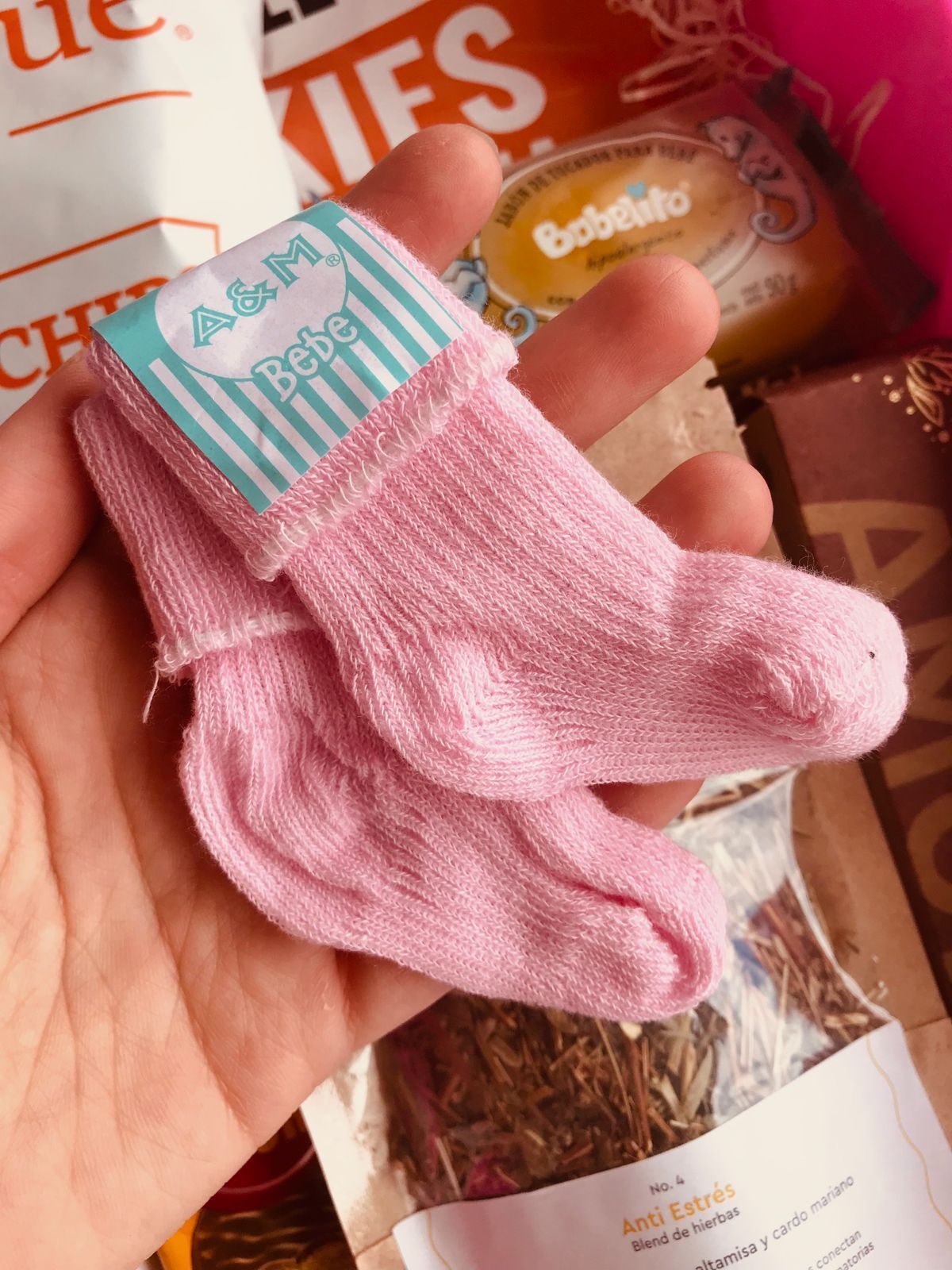 Una persona sostiene un par de calcetines rosas de bebé.