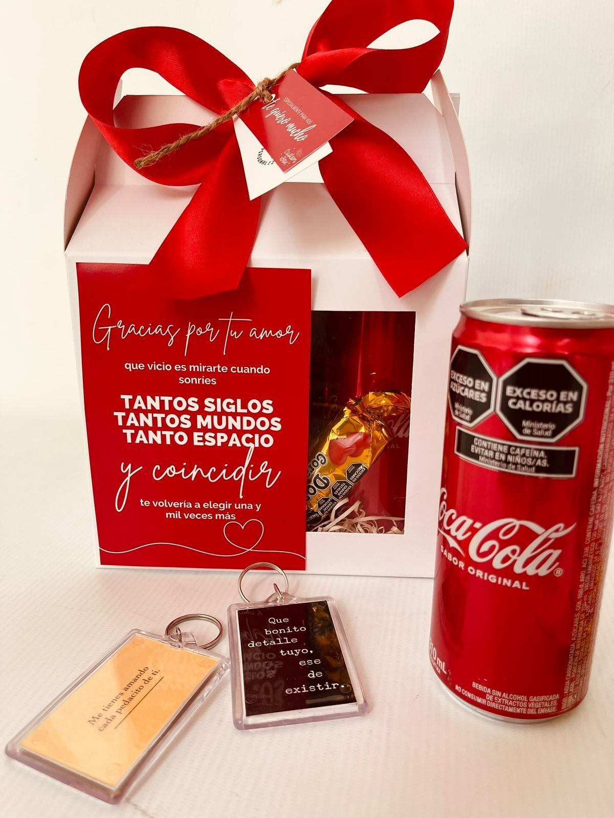 Una lata de Coca Cola se encuentra junto a una caja de regalo.