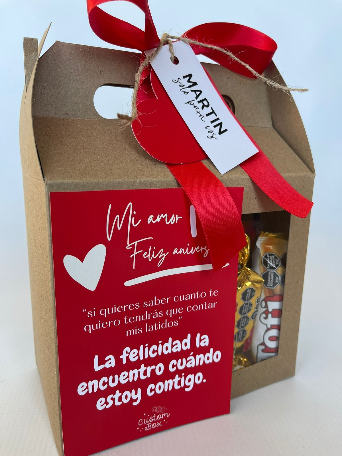 Una lata de Coca Cola se encuentra junto a una caja de regalo.