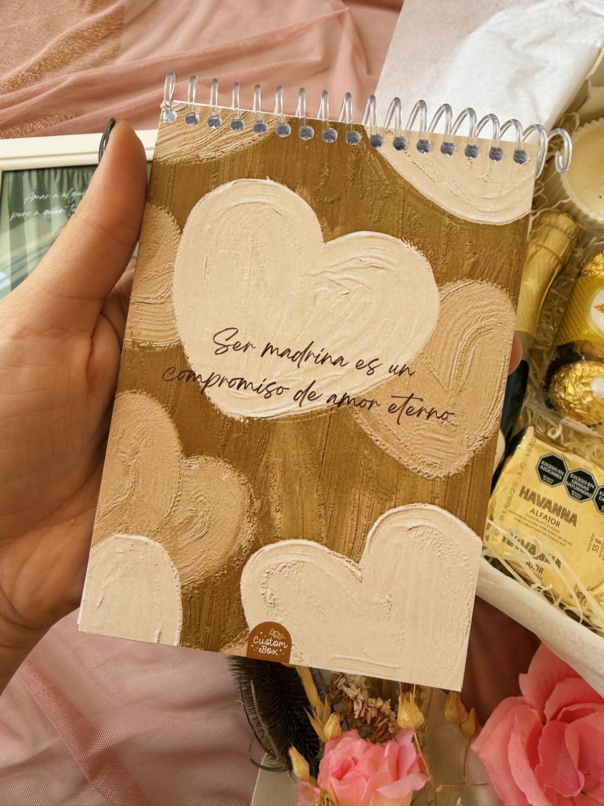 Una caja llena de una botella de champán, bombones y una vela.