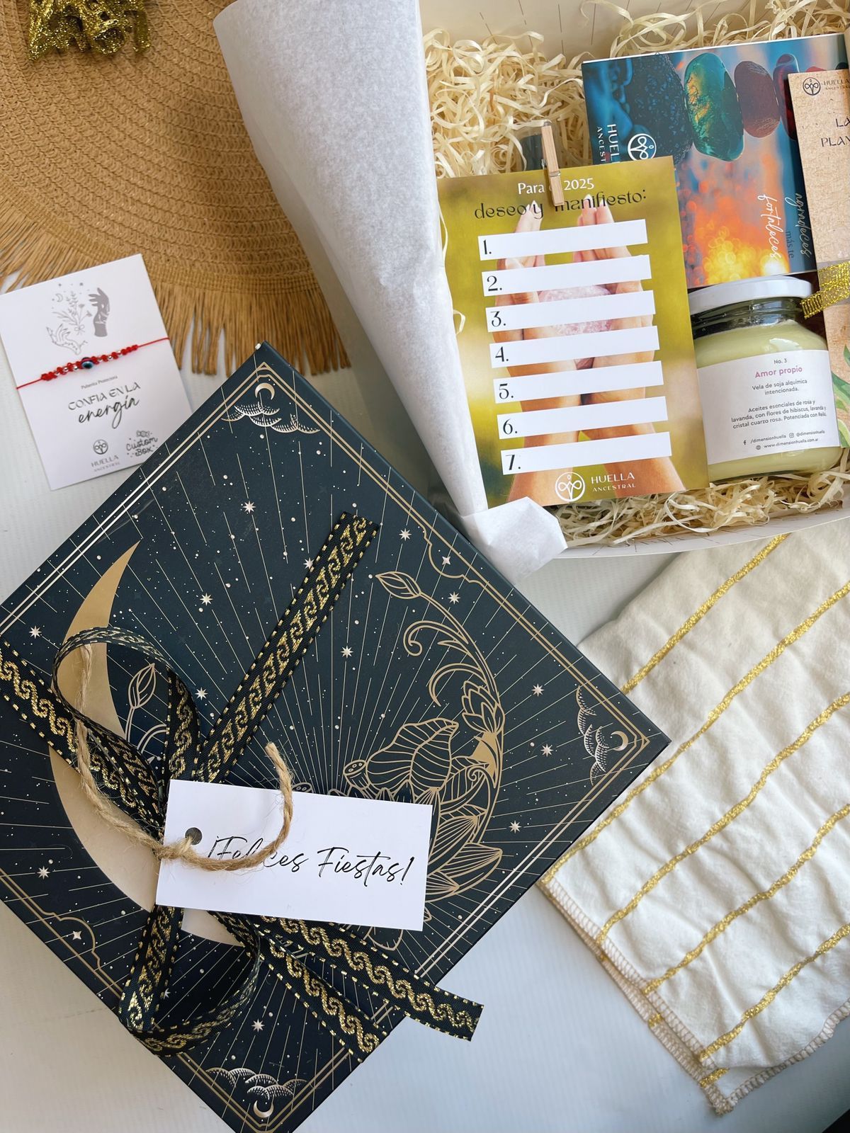 Una caja llena de una variedad de artículos, incluido un libro y una vela.