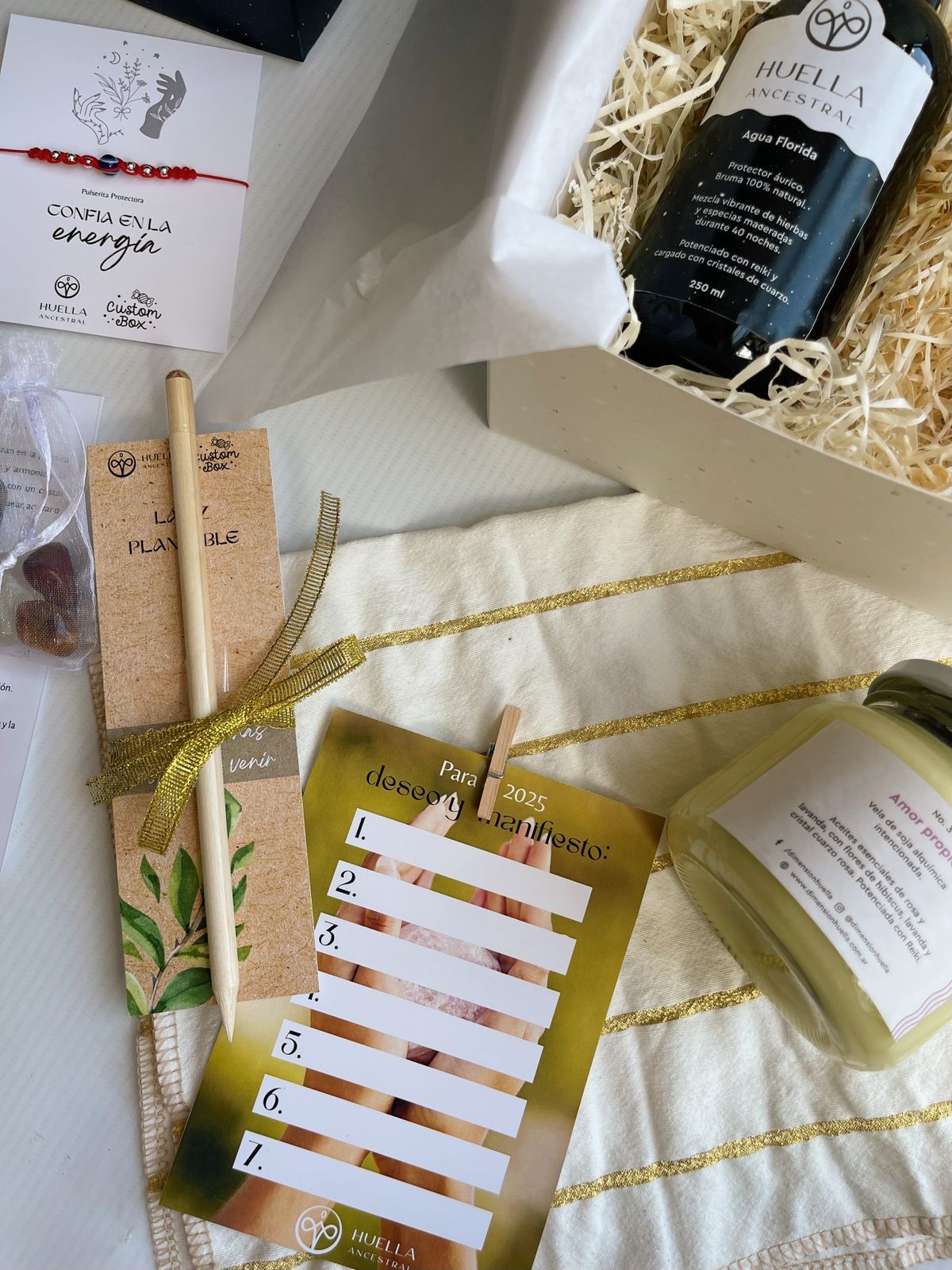 Una caja llena de una variedad de artículos, incluido un libro y una vela.