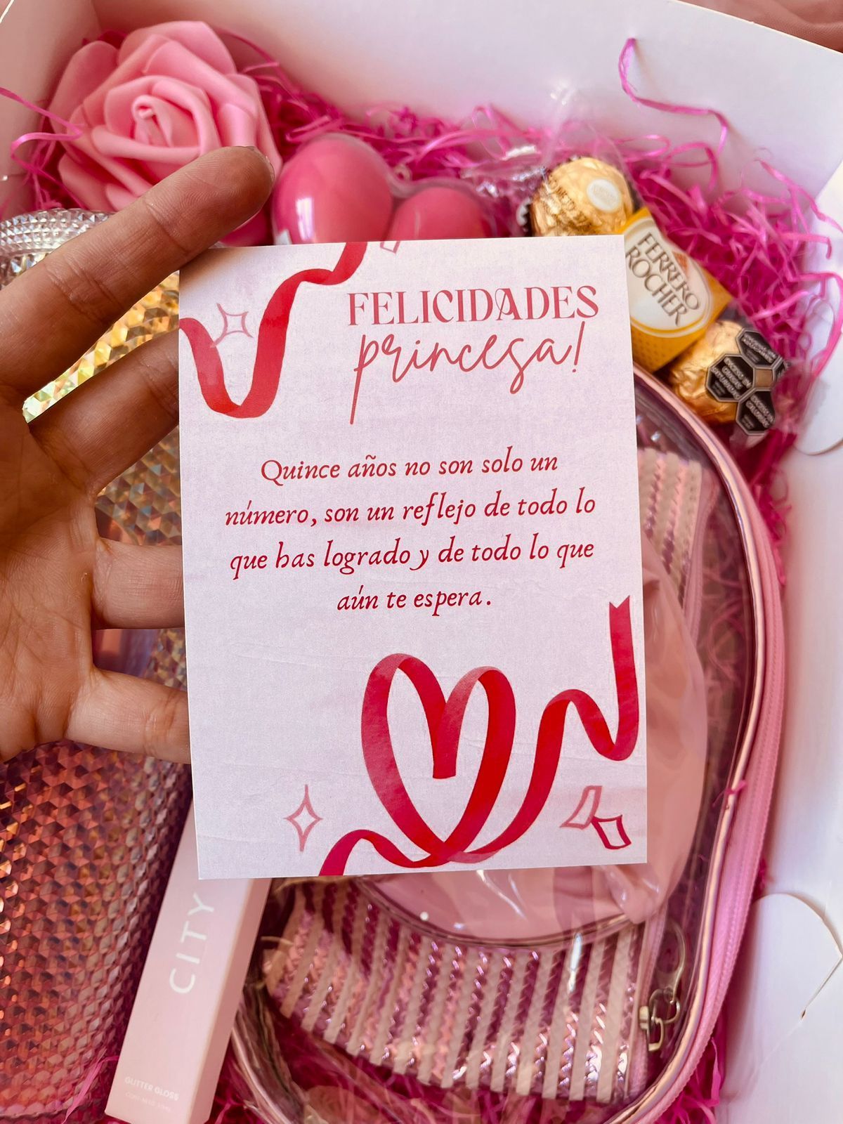 Una caja llena de flores, una pulsera y una taza