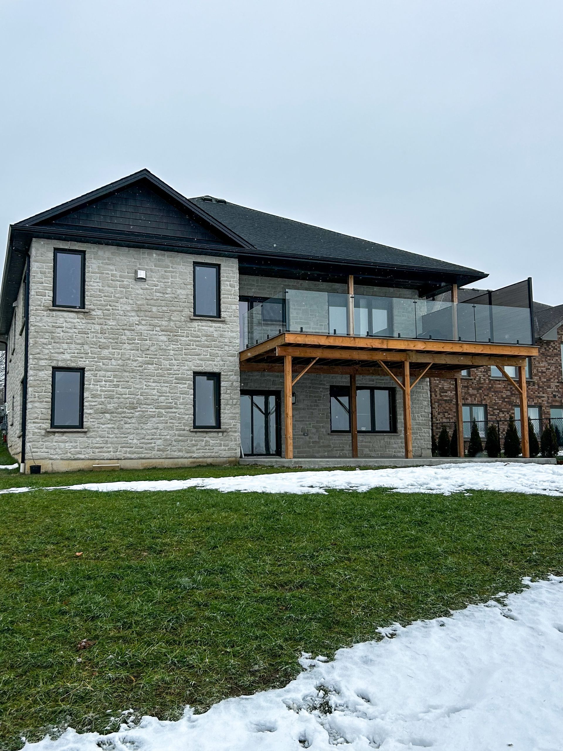 A large house with a balcony and a large lawn in front of it.