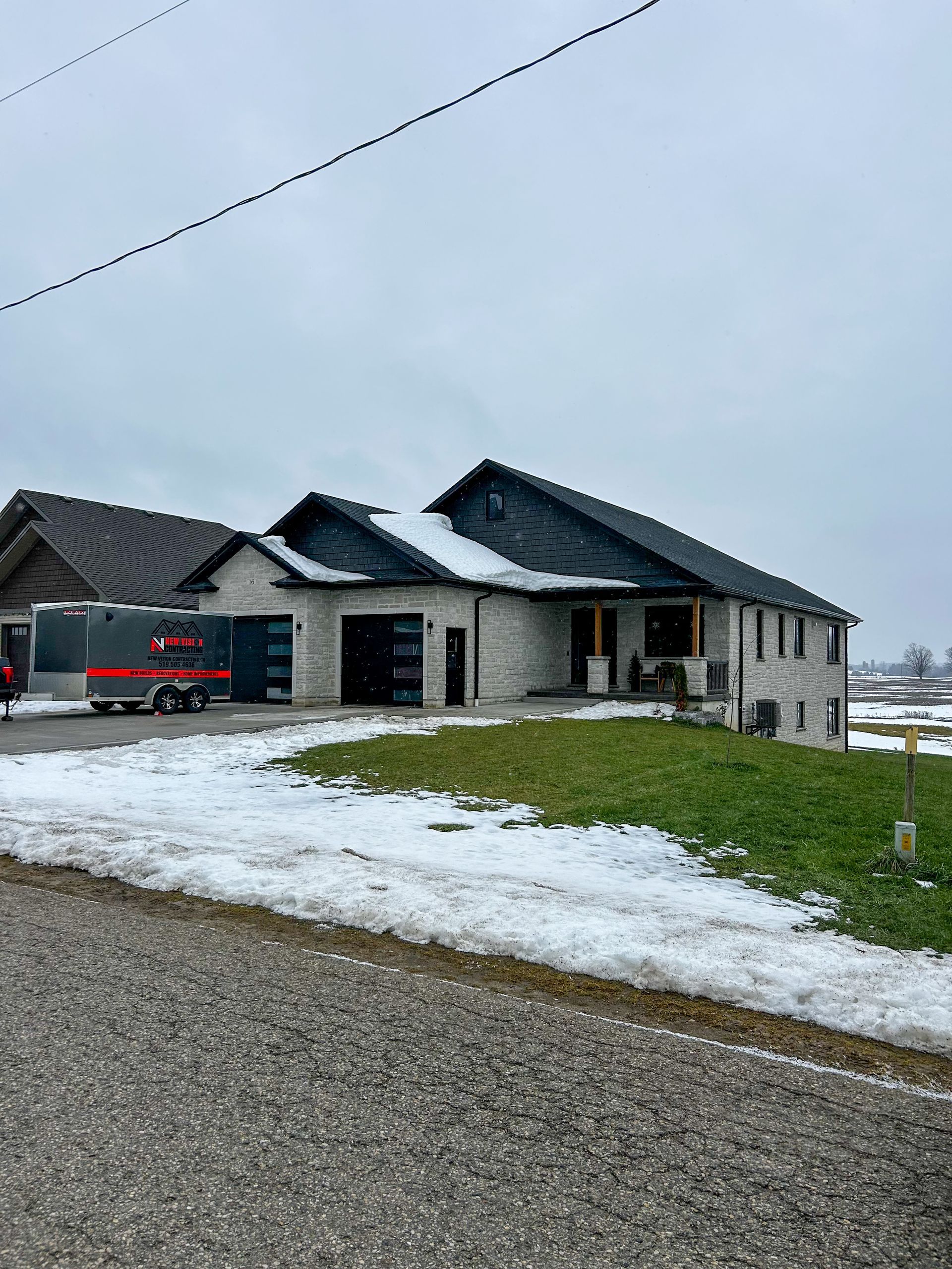 A large house with snow on the ground and a truck parked in front of it.