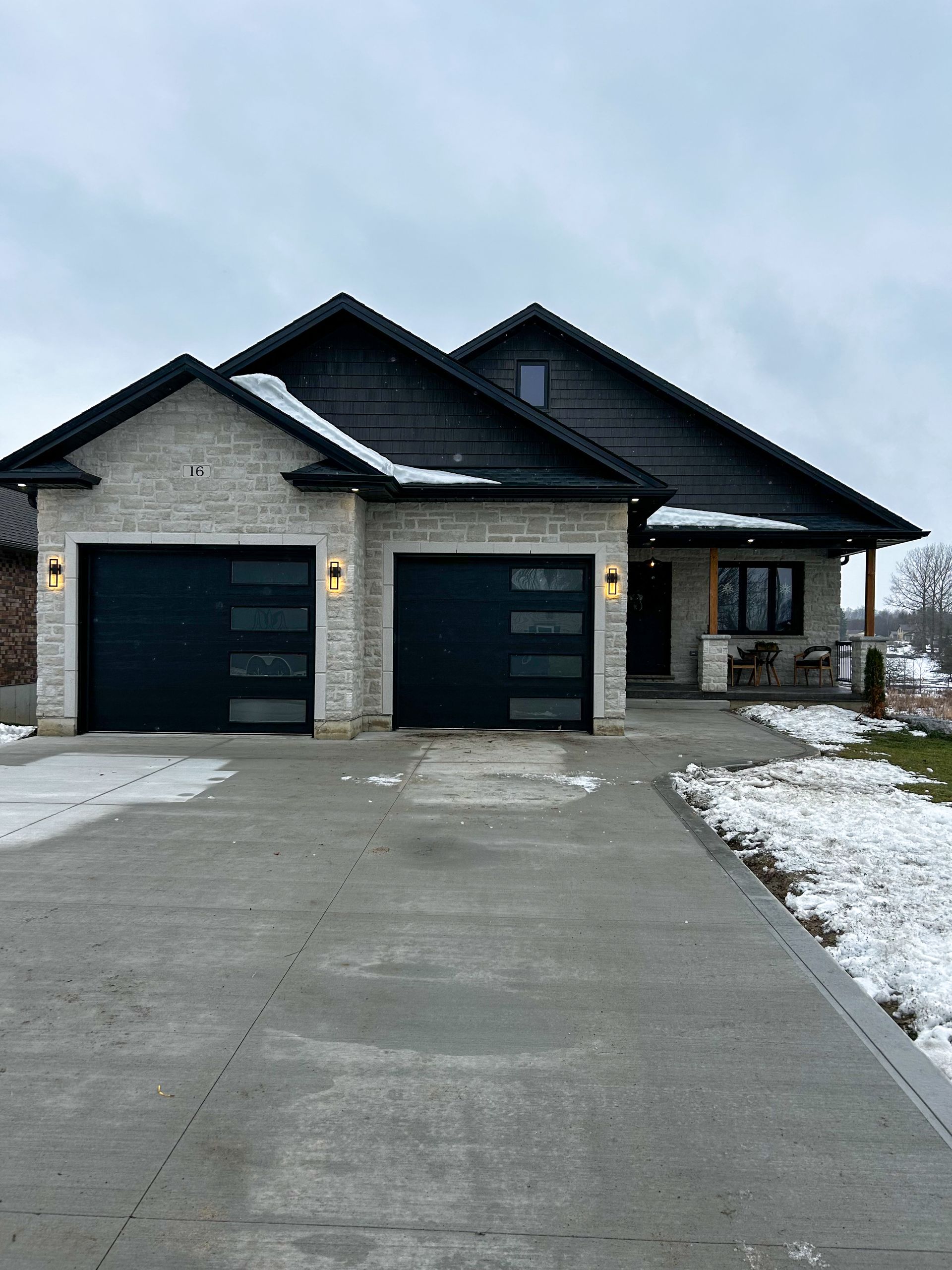 A house with two garage doors and a driveway in front of it.