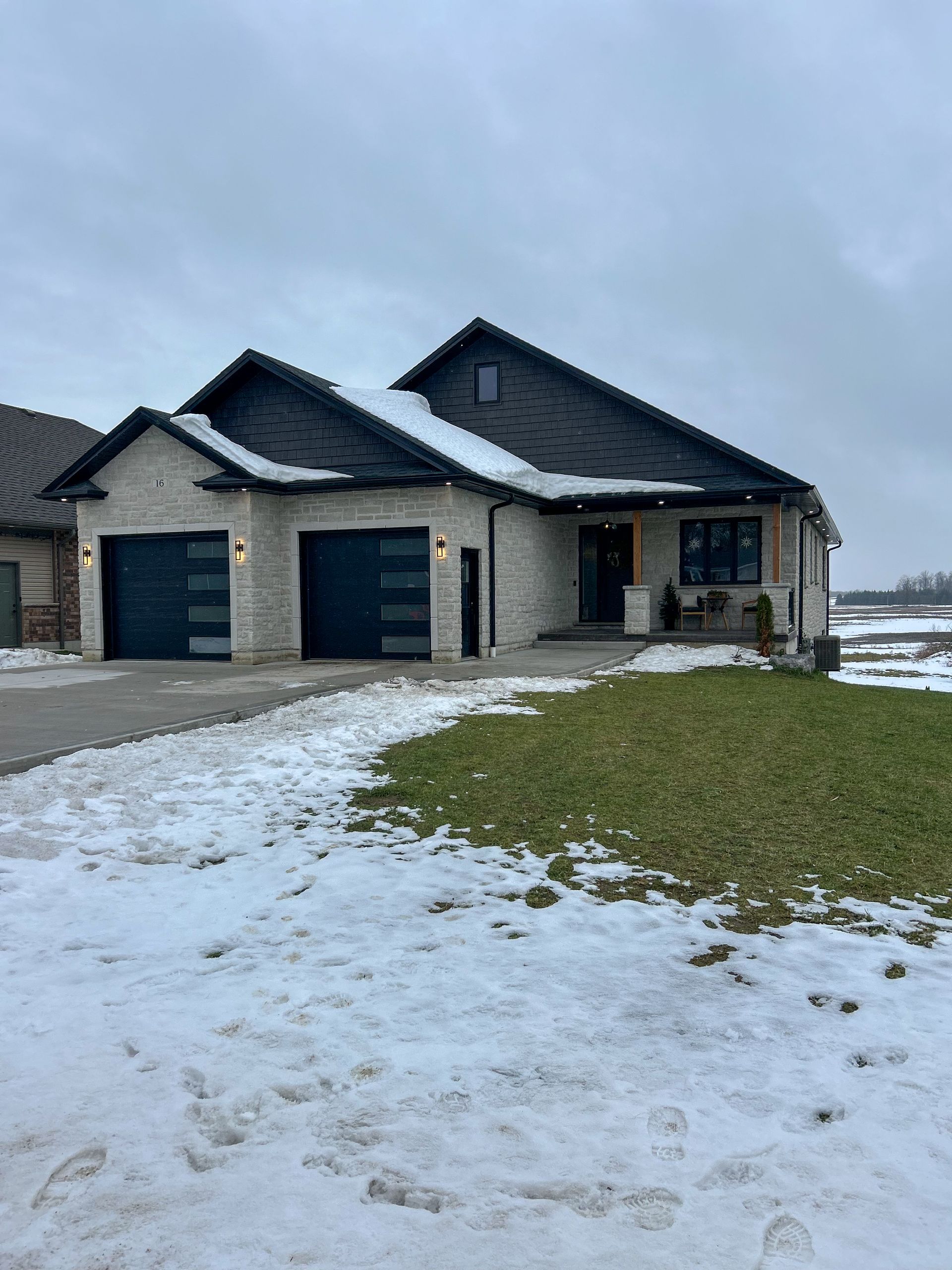 A large house with a lot of snow on the ground in front of it.