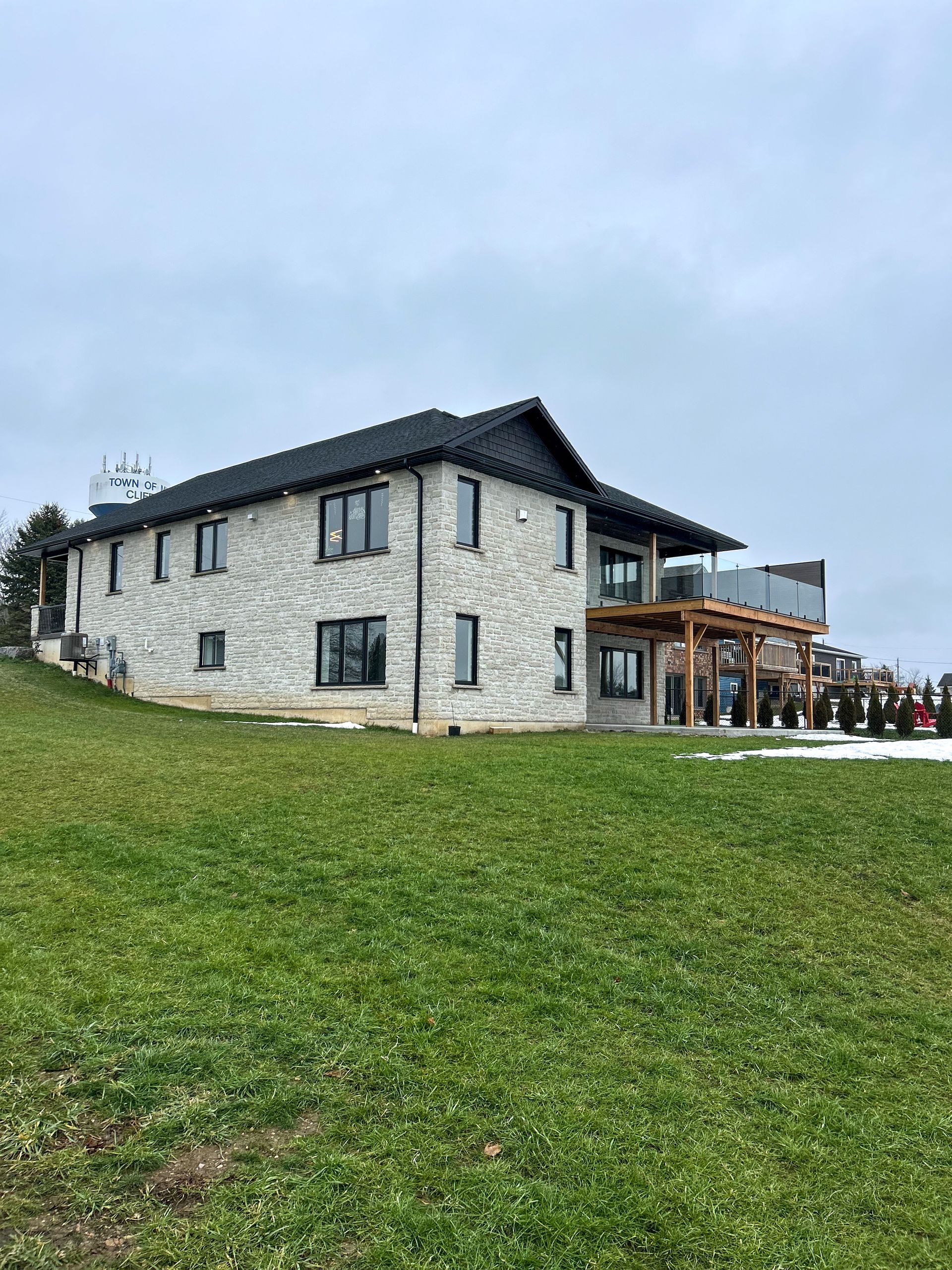 A large house is sitting on top of a lush green hillside.