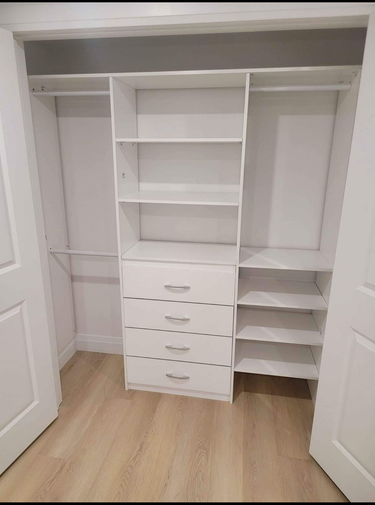 A walk in closet with lots of shelves and drawers.
