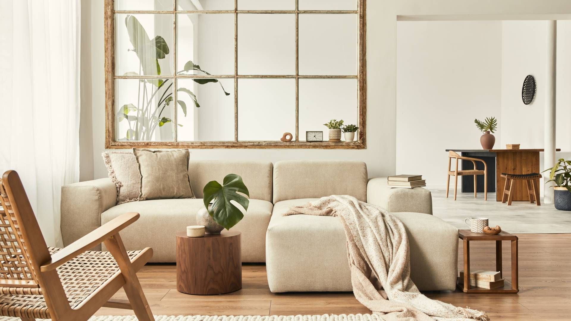 A living room with a couch , chair , table and mirror.
