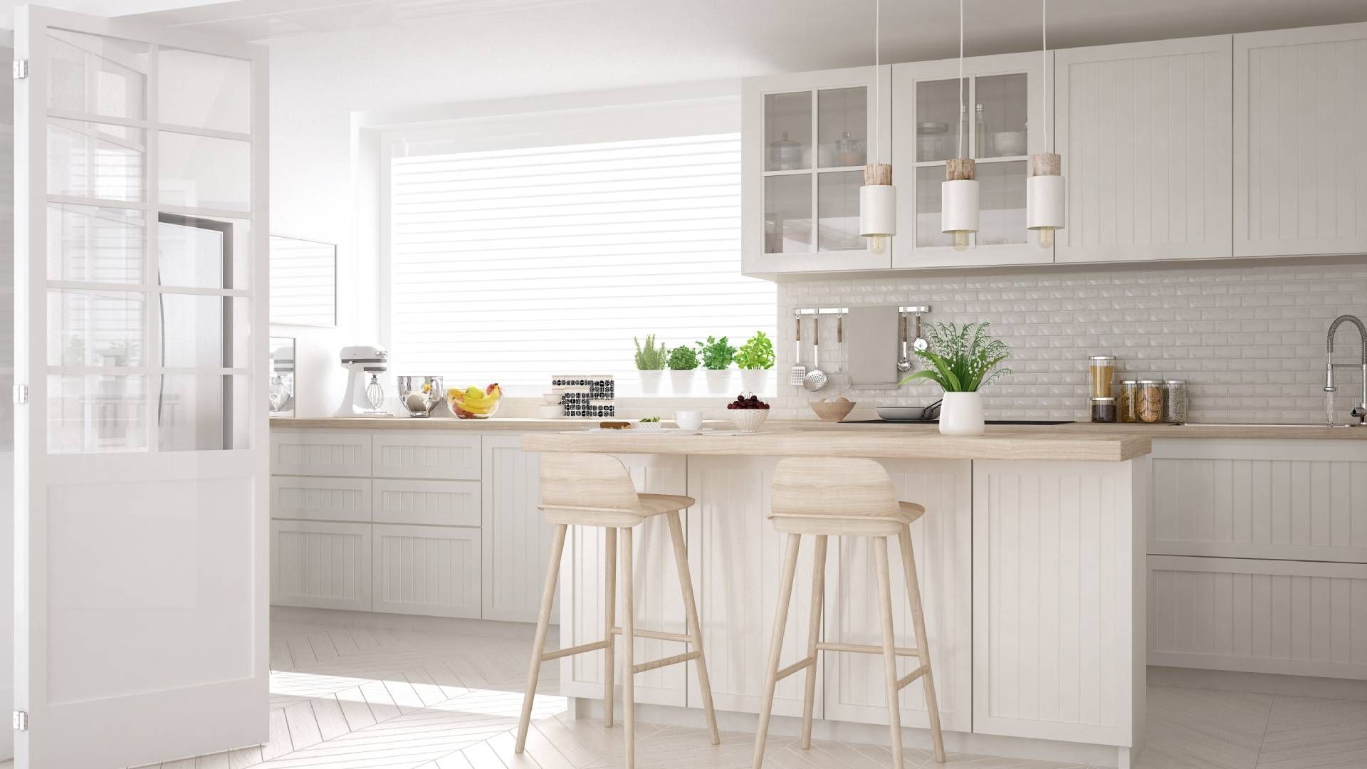 A kitchen with white cabinets , wooden counter tops and stools.