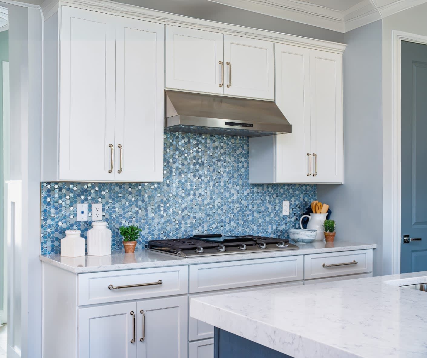 A kitchen with white cabinets and a stove top oven
