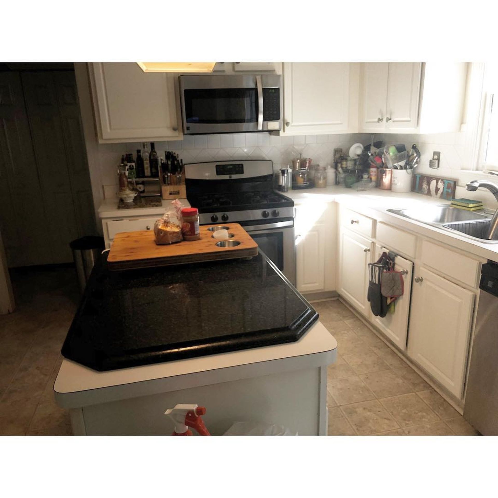 A kitchen with a stove , microwave and sink