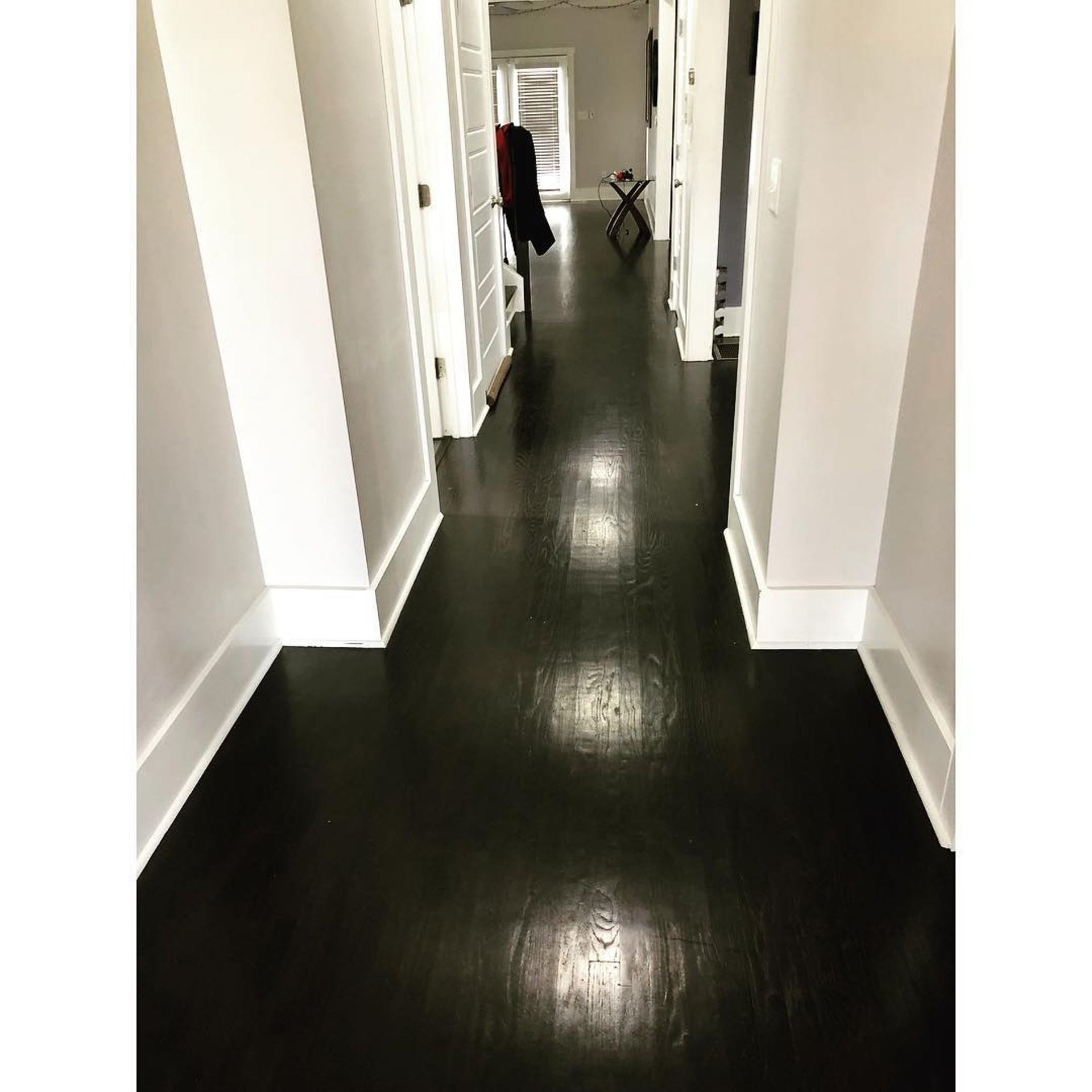 A hallway with a black floor and white walls