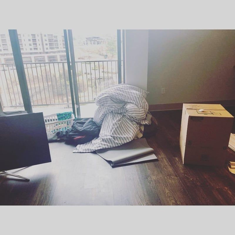 A messy room with a cardboard box on the floor