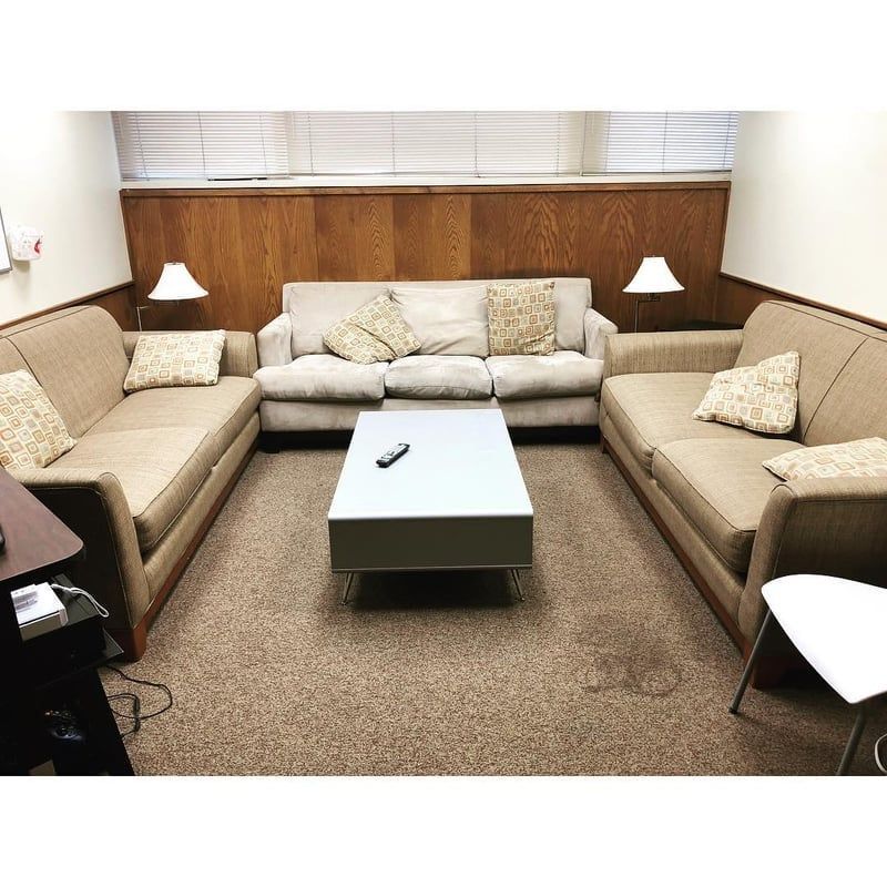 A living room with three couches and a coffee table