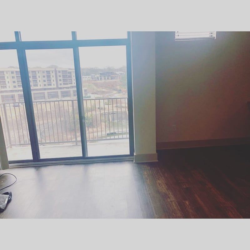 An empty room with a sliding glass door and a balcony.