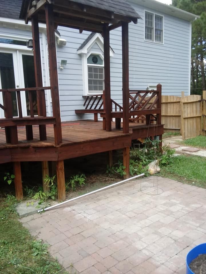 A blue house with a wooden deck in front of it
