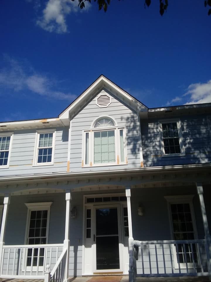 A house with a porch and a blue sky in the background